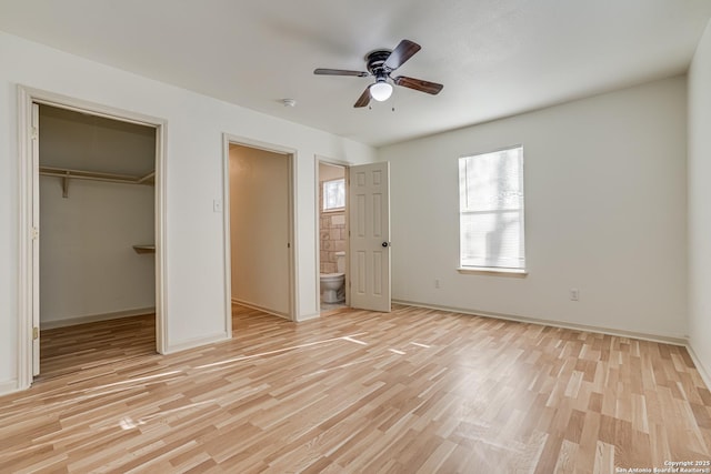 318 Elks, San Antonio, TX 78211 - unfurnished bedroom with light wood-type flooring, a spacious closet, ensuite bathroom, baseboards, and a closet