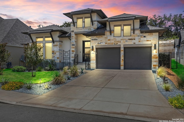 view of front of home featuring stone siding, concrete driveway, and stucco siding