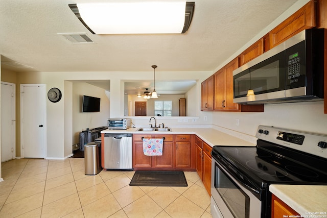 623 Cherokee, New Braunfels, TX 78132 - kitchen featuring appliances with stainless steel finishes, a sink, light countertops, brown cabinetry, and light tile patterned flooring