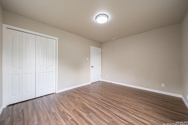 4915 Clark, San Antonio, TX 78223 - unfurnished bedroom featuring baseboards, dark wood-style flooring, and a closet