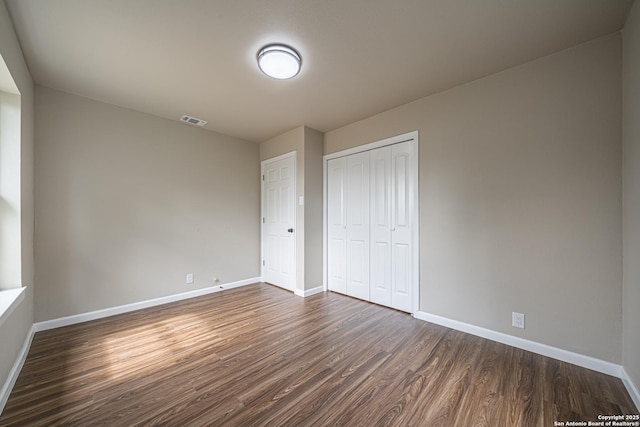 4915 Clark, San Antonio, TX 78223 - unfurnished bedroom featuring dark wood-type flooring, baseboards, and a closet
