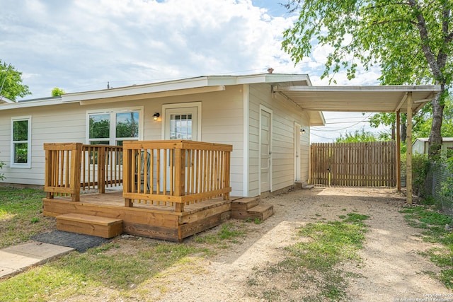 4915 Clark, San Antonio, TX 78223 - view of front of house featuring fence, a deck, dirt driveway, and a carport