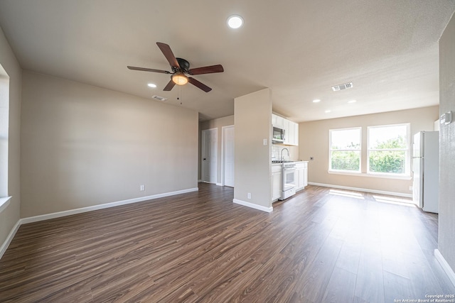 4915 Clark, San Antonio, TX 78223 - unfurnished living room with ceiling fan, dark wood-style floors, baseboards, recessed lighting, and a sink