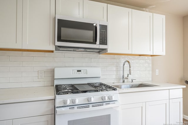 4915 Clark, San Antonio, TX 78223 - kitchen featuring white range with gas stovetop, stainless steel microwave, a sink, tasteful backsplash, and white cabinets