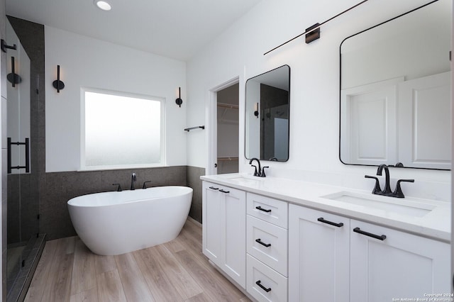 580 Compass Rose, Canyon Lake, TX 78133 - bathroom featuring tile walls, a stall shower, a soaking tub, double vanity, and a wainscoted wall