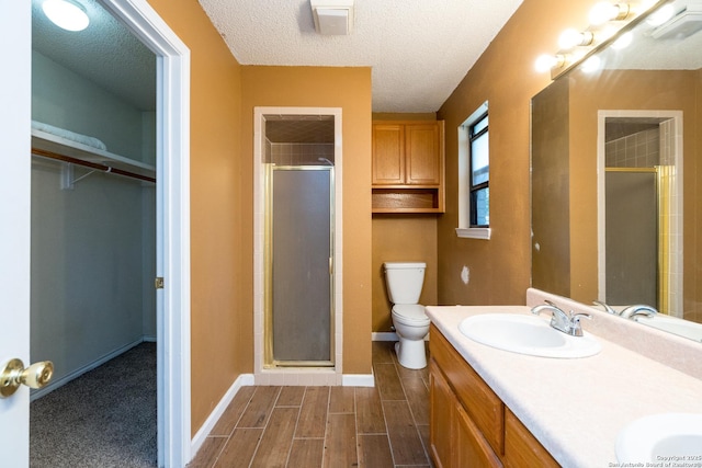 8013 County Road 128, Floresville, TX 78114 - bathroom featuring a shower stall, a textured ceiling, toilet, baseboards, and a spacious closet