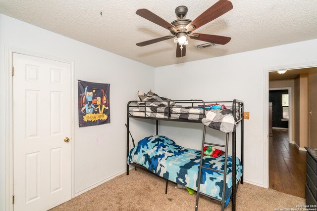 8013 County Road 128, Floresville, TX 78114 - bedroom with carpet, a textured ceiling, baseboards, and a ceiling fan
