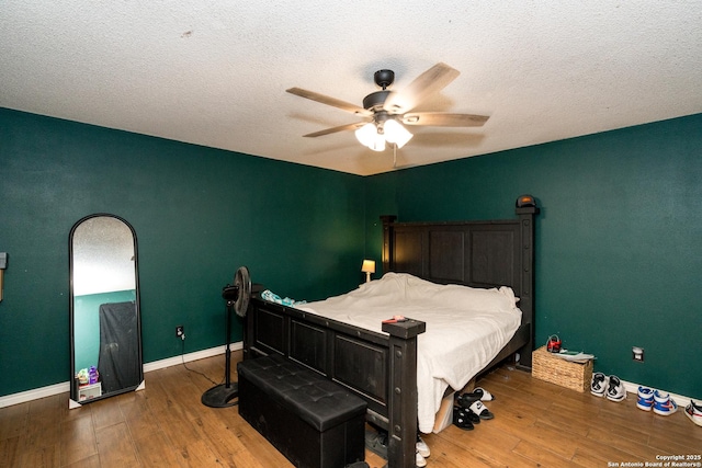 8013 County Road 128, Floresville, TX 78114 - bedroom with hardwood / wood-style floors, baseboards, a ceiling fan, and a textured ceiling