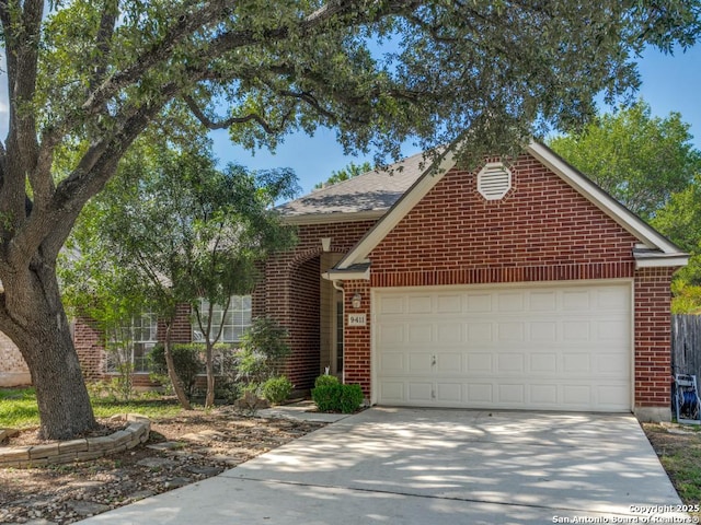 9411 Camino Venado, Helotes, TX 78023 - traditional-style house with brick siding, an attached garage, concrete driveway, and roof with shingles