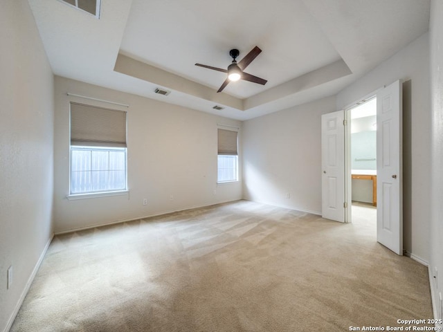 9411 Camino Venado, Helotes, TX 78023 - empty room with a tray ceiling, a ceiling fan, light colored carpet, and baseboards