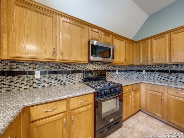 9411 Camino Venado, Helotes, TX 78023 - kitchen with black range with gas stovetop, stainless steel microwave, lofted ceiling, tasteful backsplash, and light tile patterned flooring