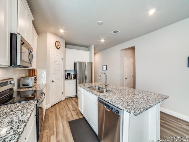 3075 Mondavi Crst, Schertz, TX 78154 - kitchen featuring appliances with stainless steel finishes, a sink, light wood-type flooring, a center island with sink, and recessed lighting