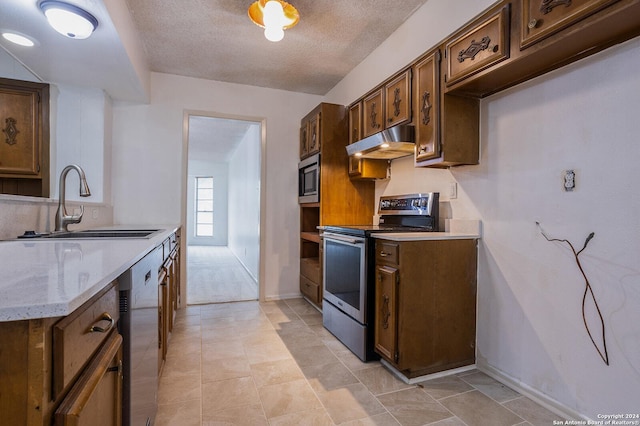 10503 Luzon Dr, San Antonio, TX 78217 - kitchen with stainless steel appliances, under cabinet range hood, a sink, baseboards, and a textured ceiling