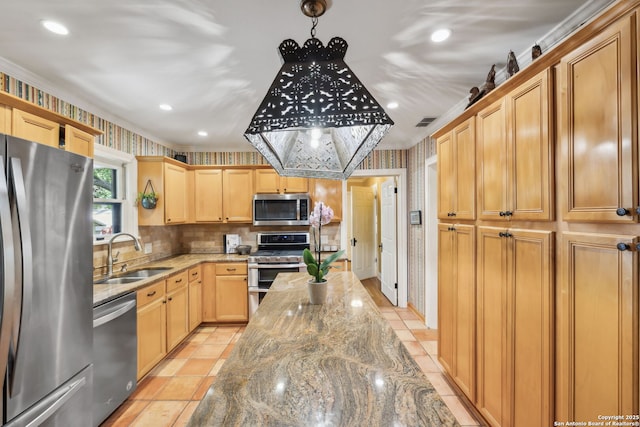 261 Fair Oaks, Alamo Heights, TX 78209 - kitchen featuring appliances with stainless steel finishes, a sink, light stone counters, wallpapered walls, and decorative light fixtures