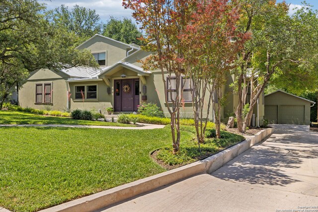 261 Fair Oaks, Alamo Heights, TX 78209 - view of front of house featuring stucco siding, an outbuilding, a detached garage, a front yard, and metal roof
