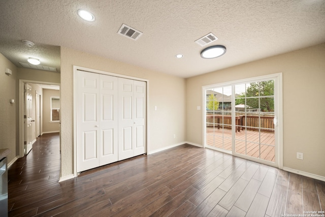 10438 Sun Ml, San Antonio, TX 78254 - unfurnished bedroom featuring access to outside, a textured ceiling, dark wood-type flooring, baseboards, and a closet