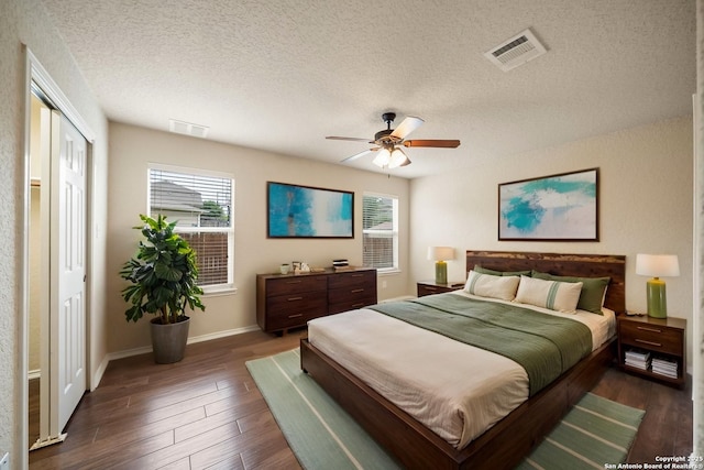 10438 Sun Ml, San Antonio, TX 78254 - bedroom with dark wood-style floors, multiple windows, a textured ceiling, baseboards, and ceiling fan