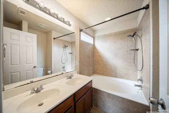 10438 Sun Ml, San Antonio, TX 78254 - full bathroom featuring tiled shower / bath combo, toilet, double vanity, and a textured ceiling