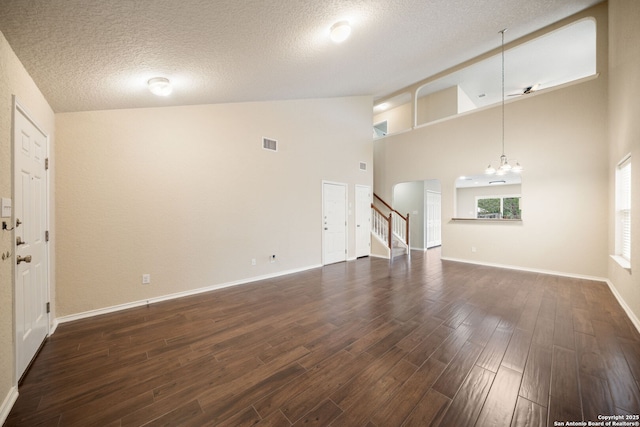 10438 Sun Ml, San Antonio, TX 78254 - unfurnished living room with dark wood-style flooring, stairs, arched walkways, a chandelier, and high vaulted ceiling