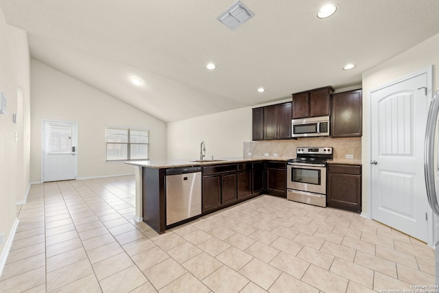1407 Frio Eagle, San Antonio, TX 78245 - kitchen featuring appliances with stainless steel finishes, decorative backsplash, a sink, dark brown cabinets, and a peninsula