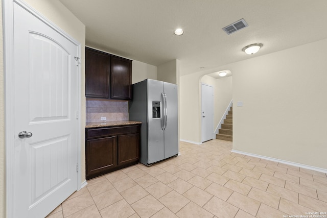 1407 Frio Eagle, San Antonio, TX 78245 - kitchen featuring stainless steel refrigerator with ice dispenser, dark brown cabinets, backsplash, baseboards, and light tile patterned floors