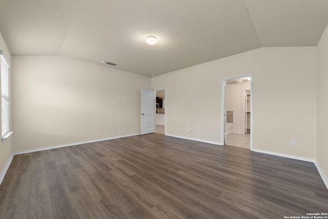 1407 Frio Eagle, San Antonio, TX 78245 - unfurnished bedroom featuring vaulted ceiling, dark wood-style flooring, baseboards, and ensuite bath