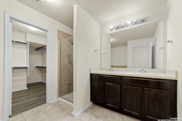 1407 Frio Eagle, San Antonio, TX 78245 - full bathroom featuring a stall shower, a spacious closet, tile patterned floors, and double vanity