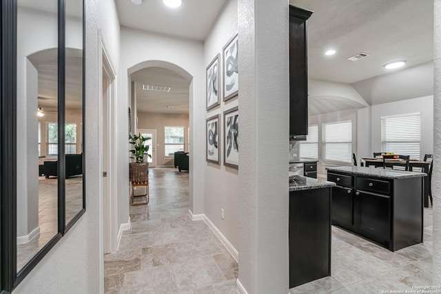 25725 Two Spgs, San Antonio, TX 78255 - hallway with arched walkways, light stone finish floors, baseboards, plenty of natural light, and recessed lighting