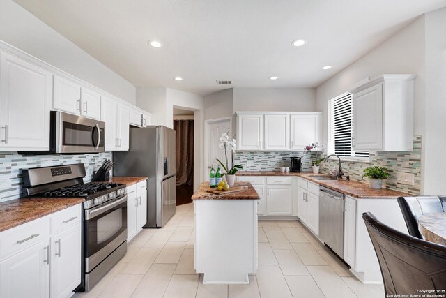20607 Wild Spgs, San Antonio, TX 78258 - kitchen featuring stainless steel appliances, a sink, white cabinets, a center island, and decorative backsplash