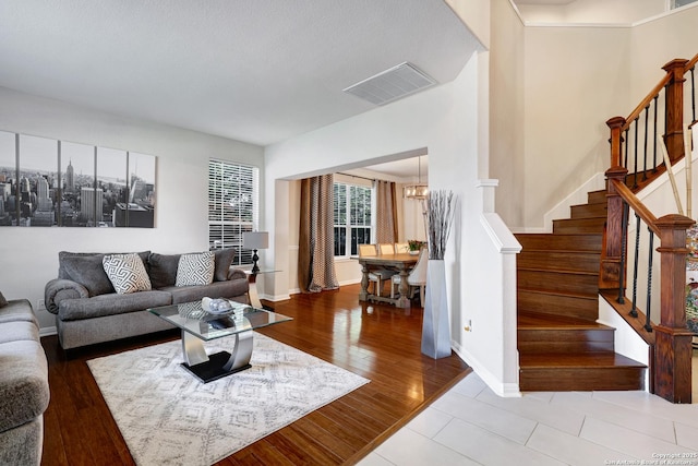 20607 Wild Spgs, San Antonio, TX 78258 - living room featuring a chandelier, stairs, baseboards, and wood finished floors