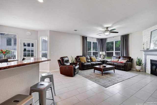 20607 Wild Spgs, San Antonio, TX 78258 - living area with ceiling fan, a large fireplace, baseboards, and light tile patterned floors