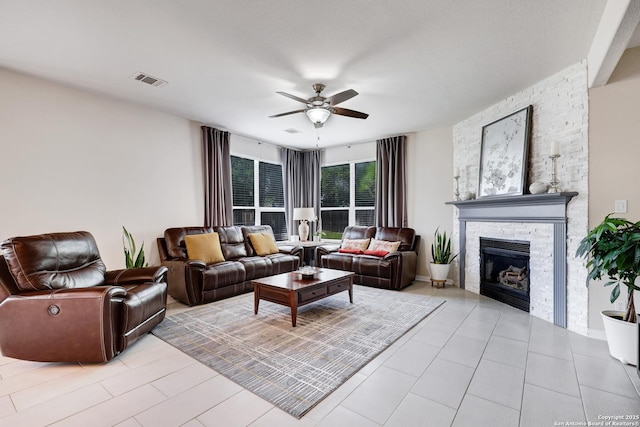 20607 Wild Spgs, San Antonio, TX 78258 - living room with ceiling fan, a stone fireplace, and light tile patterned flooring