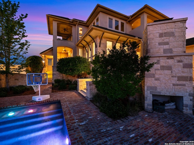 52 Oakland Hls, Boerne, TX 78006 - view of front facade with stucco siding, an outdoor stone fireplace, a balcony, and stone siding