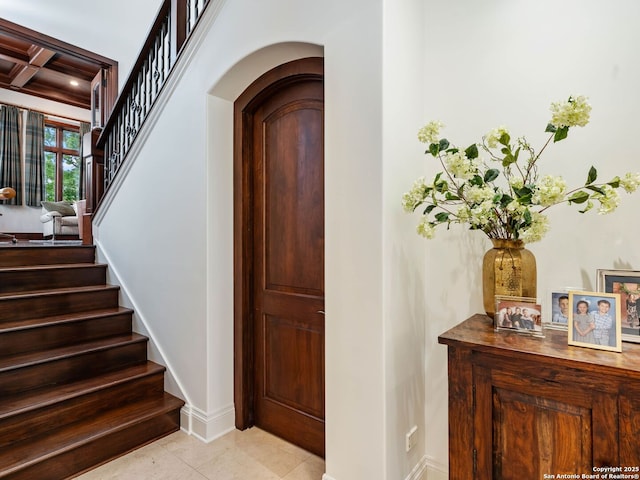 52 Oakland Hls, Boerne, TX 78006 - stairway featuring baseboards, arched walkways, tile patterned flooring, beam ceiling, and coffered ceiling