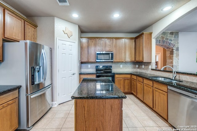 21835 Seminole Oaks, San Antonio, TX 78261 - kitchen with appliances with stainless steel finishes, a sink, dark stone countertops, a kitchen island, and tasteful backsplash
