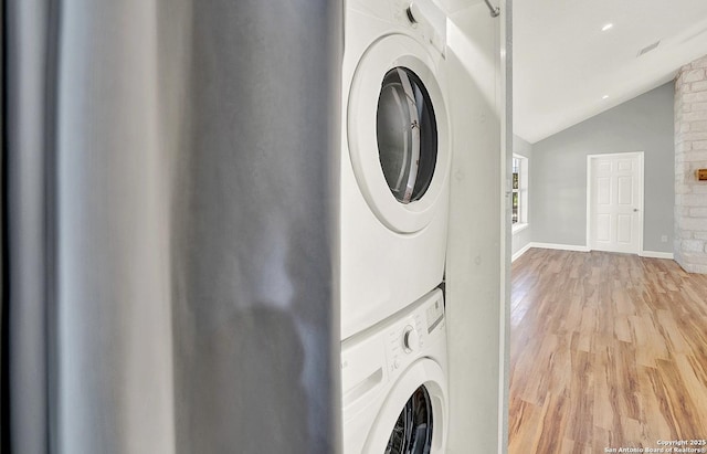 661 Abels Way, Canyon Lake, TX 78133 - laundry room with stacked washing machine and dryer, light wood-type flooring, and baseboards