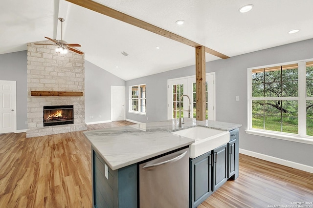 661 Abels Way, Canyon Lake, TX 78133 - kitchen with stainless steel dishwasher, a sink, a ceiling fan, light wood-style flooring, and baseboards