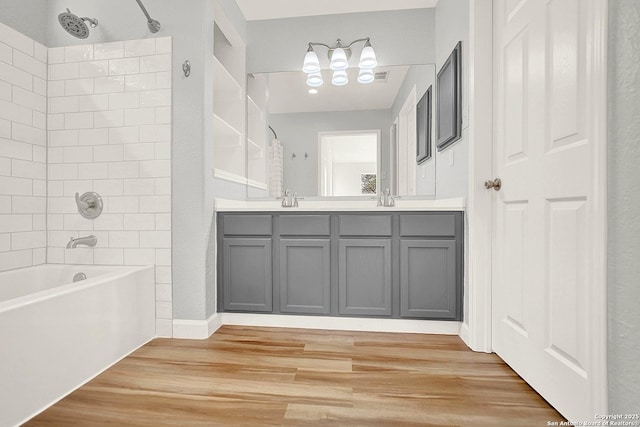661 Abels Way, Canyon Lake, TX 78133 - full bath featuring a chandelier, wood finished floors, washtub / shower combination, and double vanity