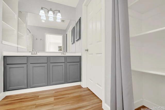 661 Abels Way, Canyon Lake, TX 78133 - bathroom featuring wood finished floors, double vanity, and curtained shower
