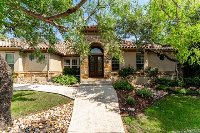 135 Penns Way, Shavano Park, TX 78231 - mediterranean / spanish house with stucco siding, a tiled roof, stone siding, and french doors