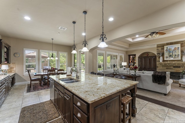 135 Penns Way, Shavano Park, TX 78231 - kitchen with a sink, light tile patterned floors, recessed lighting, dark brown cabinetry, and light stone counters