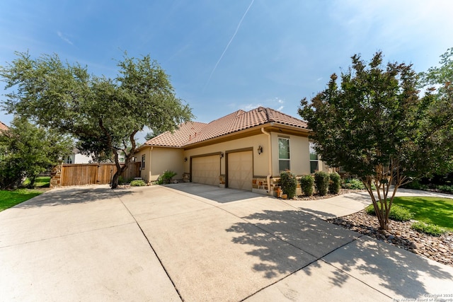 135 Penns Way, Shavano Park, TX 78231 - mediterranean / spanish-style house featuring a garage, a tile roof, fence, driveway, and stucco siding