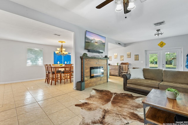 25 Zoeller Ln, Boerne, TX 78006 - tiled living room featuring a ceiling fan, a glass covered fireplace, a chandelier, and baseboards