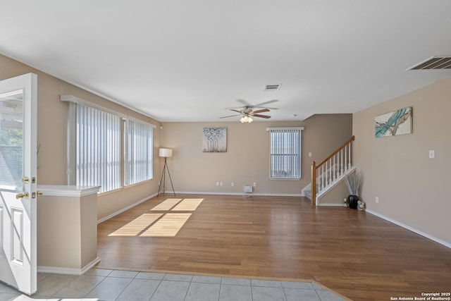 1427 Alaskan Wolf, San Antonio, TX 78245 - unfurnished living room with wood finished floors, plenty of natural light, a ceiling fan, and stairs