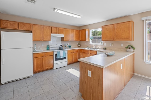 1427 Alaskan Wolf, San Antonio, TX 78245 - kitchen featuring white appliances, under cabinet range hood, light tile patterned floors, a peninsula, and light countertops