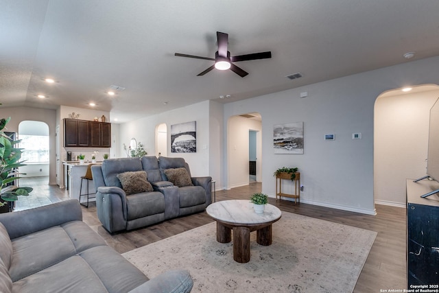 9614 Tupelo Holw, San Antonio, TX 78254 - living room featuring arched walkways, a ceiling fan, light wood-style floors, baseboards, and recessed lighting