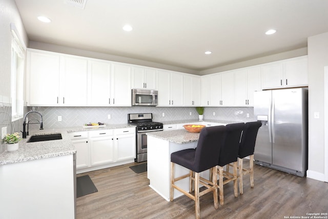12890 Limestone Way, San Antonio, TX 78253 - kitchen with stainless steel appliances, a sink, a kitchen island, light wood-style floors, and recessed lighting
