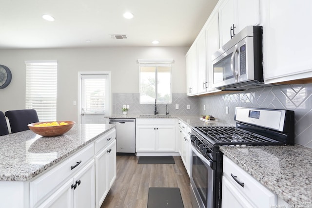 12890 Limestone Way, San Antonio, TX 78253 - kitchen with stainless steel appliances, a sink, wood finished floors, white cabinetry, and light stone countertops