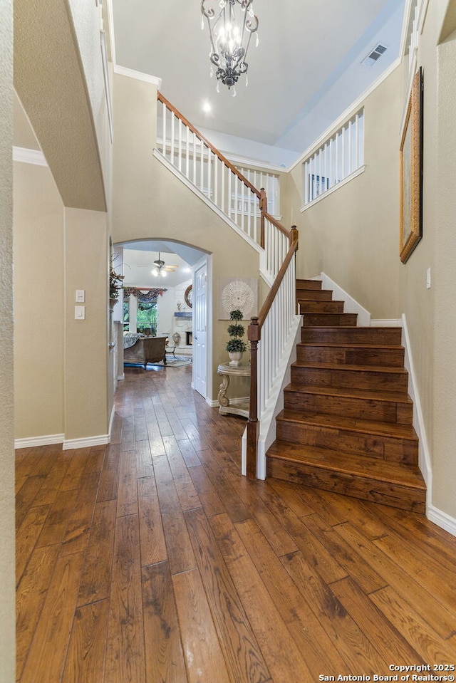 26019 Meadowlark Bay, San Antonio, TX 78260 - entryway with stairs, arched walkways, hardwood / wood-style flooring, baseboards, and a towering ceiling