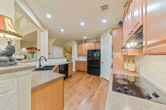 26019 Meadowlark Bay, San Antonio, TX 78260 - kitchen with black appliances, under cabinet range hood, a sink, light wood-type flooring, and backsplash